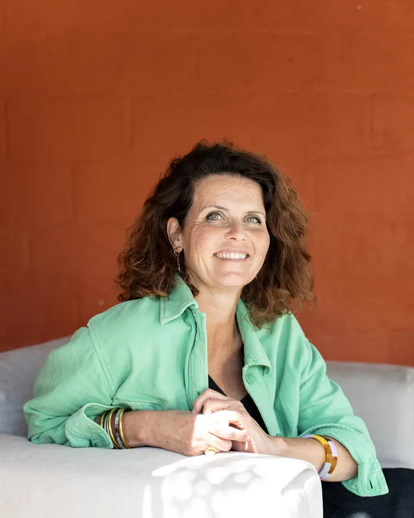 Alexandra Sorin, thérapeute systémique à Saint-Nazaire, souriante sur le canapé de son cabinet